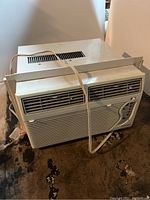 Front and top view of Fedders air conditioner showing vents, adjustable side panel, and power cord.