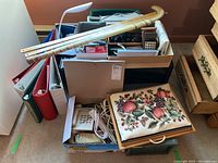 Shows full top view of all items in boxes including the desk lamp, binders, telephone, cane, and stationery supplies.