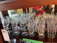 Photo showing a variety of etched glass stemware including wine glasses, aperitif glasses, and martini glasses displayed on a reflective surface.