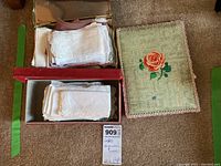 Two storage boxes open showing lengthwise folded vintage ladies handkerchiefs, varying designs and colors visible.