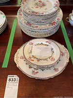 Multiple bone china plates stacked showing floral and pagoda designs typical of the Paragon Chinese Garden pattern along with Sone China plates.