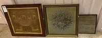 Three framed petit point embroidery samplers displayed side by side