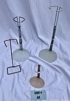 Four doll stands arranged on white backdrop showing varying sizes and colors.