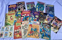 Wide overhead shot showing all vintage comic books with colorful covers featuring cartoon characters Woody Woodpecker, Tweety & Sylvester, Little Audrey, and superhero comics including Superman, Captain America, Daredevil.