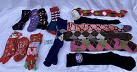 All 14 pairs of novelty socks displayed on a white background, showing different colors, patterns and holiday designs