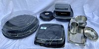 Full view of all plastic and metal serving dishes including trays and cups.