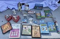All Snoopy items arranged on lavender fabric background showing full lot contents.