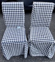 Front view of two chairs covered in blue and white checkered floor-length covers