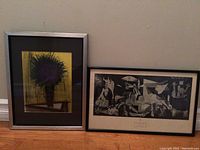Two framed art prints side by side; one colorful flower print in silver frame, one black-and-white Picasso Guernica reproduction in black frame.
