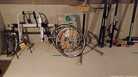 Overview of repair stand, bike rack components, wheels and upright racks on basement floor