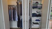 Closet view with hanging suit jackets and dress shirts on left, folded items and hats on right shelving