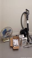 Full view of Sebo vacuum, filter bag boxes, instruction manual and desk fan