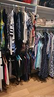 Closet rack showing two tiers of assorted women’s garments hung on hangers