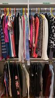 Overview of rack with assorted women's medium-sized tops and blouses in various colors