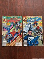 Two Amazing Spider-Man comics, one with Spider-Man and Round Robin battle scene, the other with Spider-Man, gunman and moonlit villain on cover.