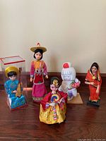 Five collectible Asian dolls shown together representing various countries.