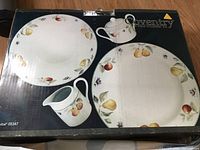 Photo of the box displaying the full 4-piece set with the fruit-patterned porcelain pieces