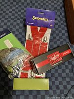 Five bowties in plastic packaging, red suspenders, boxed Rawlings Pro sunglasses, wristwatch in packaging