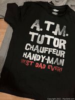 Black short-sleeve T-shirt with printed text listing roles and 'Best Dad Ever' in red.