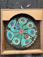 Front photo of a vintage circular Par-Darts game board with painted scoring areas and floral pattern in a wooden wall mount