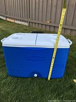 Front and side view of Rubbermaid cooler showing height measurement with tape measure