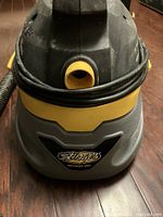 Front view of the Stinger wet/dry shop vac showing the yellow hose inlet and brand label.