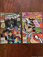 Two vintage The Amazing Spider-Man comic books showing Spider-Man fighting Venom and a villain with glasses from the series.