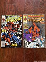 Photo showing two comic books of The Amazing Spider-Man with colorful covers. One depicts Spider-Man on a web with sharp red highlights, the other features Spider-Man with two other characters and the title 'The Assassin Nation Plot'.