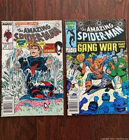 Two vintage Amazing Spider-Man comic books shown cover front – issue #315 with Venom and Spider-Man, issue #284 with Gang War cover