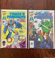 Two vintage Marvel Transformers comic books, issue #9 and #14, placed side by side showing front covers in excellent condition with protective sleeves and backer boards.
