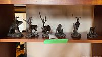 All six bronze animal figurines on shelf