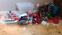 Overview of lot showing wrapping paper rolls, ornaments, stockings, gift bags, tote and mat/runner.