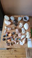 Full view of the collection of stones, shells, crystals and glass orb arranged on wooden surface