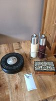 Full view of cribbage board, decorative box, salt and pepper grinders on wooden table