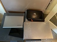 Overview of four laptops/tablet laid on a table: Toshiba, Lenovo, Compaq, ASUS Nexus Pad.