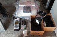 Photo showing Poynt smart terminal with parts box and ELO countertop pad in original wrapping.