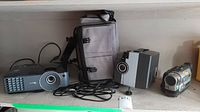 Benq MX501 digital projector on shelf with power cable and carrying case, Sanyo projector, and Sony camcorder