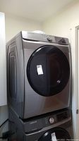 Front three-quarter view of Samsung front-load dryer on top of stacked unit
