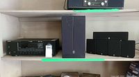 Yamaha subwoofer, speakers, and receiver placed on shelves, showing the full set.