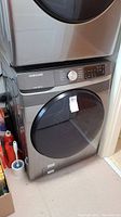 Front and side view of stacked Samsung washer in laundry room