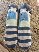 Two pairs of brand new Indigo children's reading socks with blue and white stripes and smiley faces on top