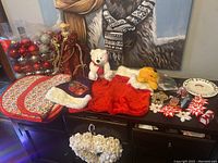 Overview of Christmas lot items on a dark wooden sideboard with painting in background