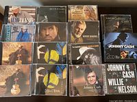Photo showing 15 country music CDs including multiple Alan Jackson CDs, a Garth Brooks CD, a Carrie Underwood CD, Kenny Rogers, Charlie Daniels Band, Dixie Chicks, and several Johnny Cash CDs including collaborations.