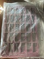 Purple silicone baking pan in plastic packaging showing 30 small rectangular mold cavities for bite-sized treats.