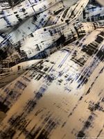 Close-up photo of the fabric showing abstract geometric pattern in navy blue, black, and white colors.