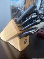 Front angle showing wooden knife block with 8 visible knives and 1 pair kitchen shears with black handles.