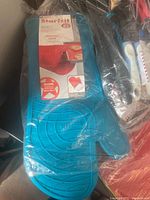 Blue Starfrit silicone oven mitt in original packaging.