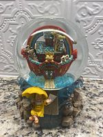 Front angled view of the water dome showing Noah's Ark with animals inside, Noah figure holding an umbrella outside the dome on a rocky base.