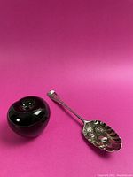 Spoon displayed alongside green apple for scale, full view of lot contents