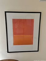 Full view of the framed modern abstract painting hanging on the wall.